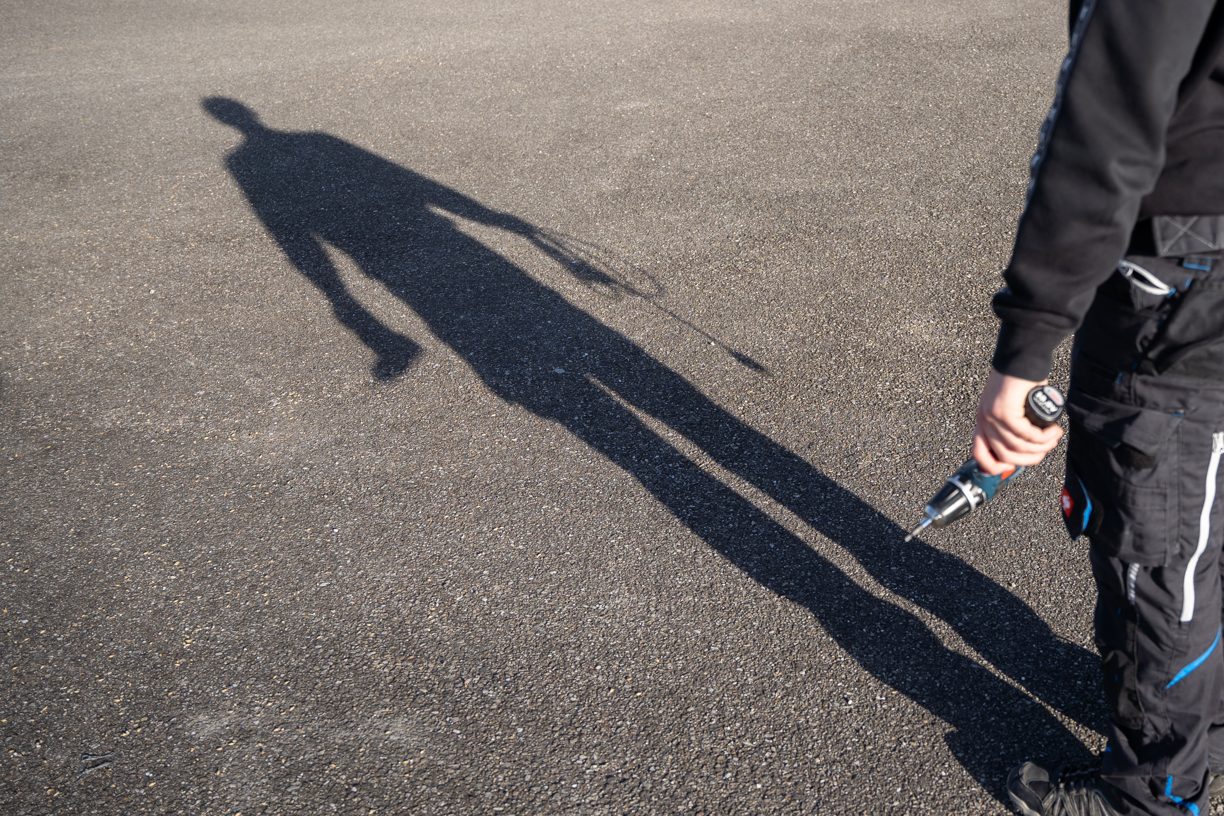 Shadow of person with drill in hand